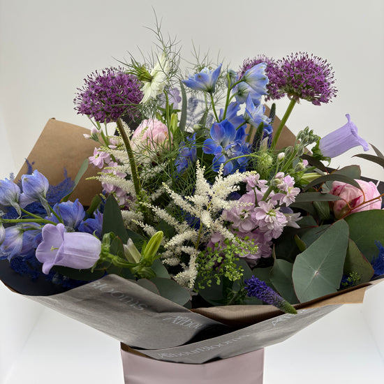 Bouquet of flowers in a box with 'Arbour Blooms' branding on a white background