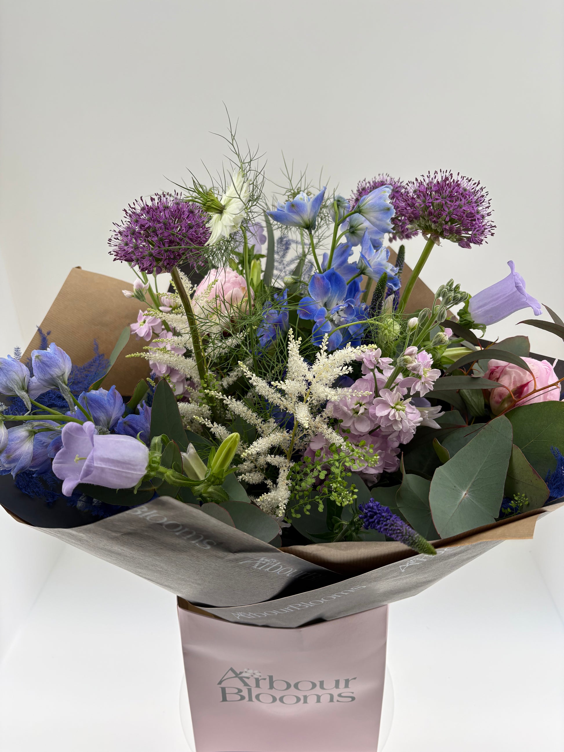 Bouquet of flowers in a box with 'Arbour Blooms' branding on a white background