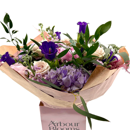 Bouquet of flowers with a visible Arbour Blooms box on a white background